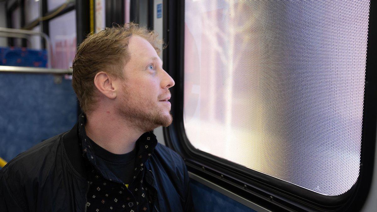 Tyler Schram looks out the window of a bus. 