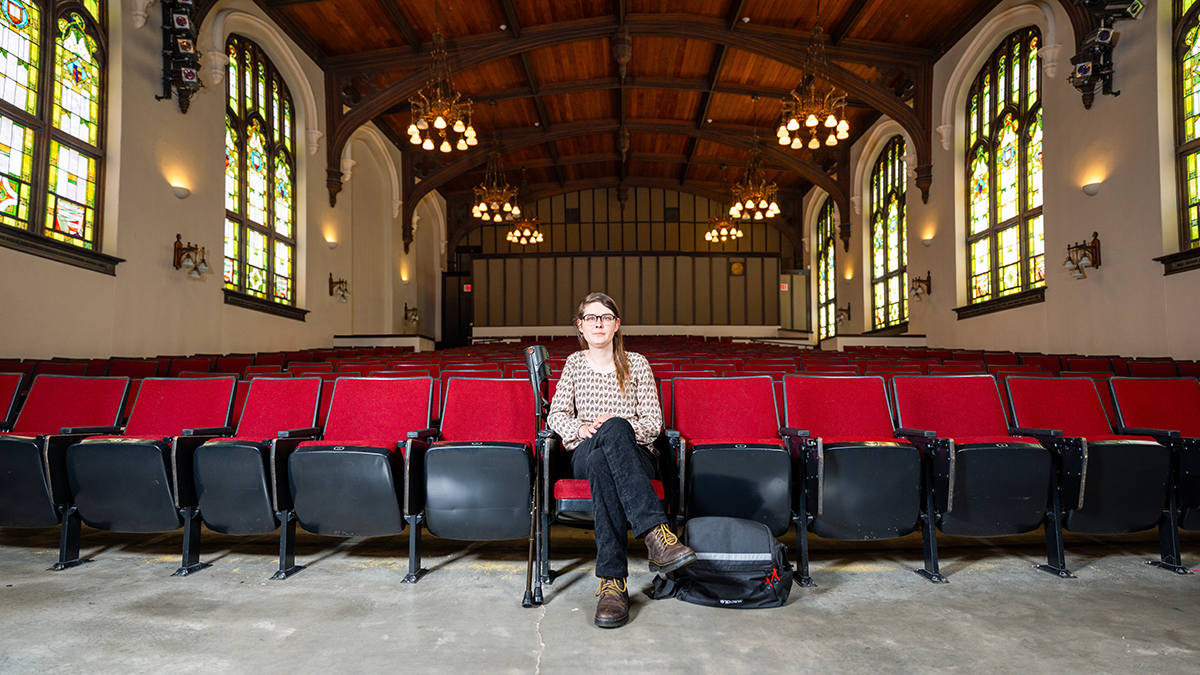 Woman sitting in empty theater.